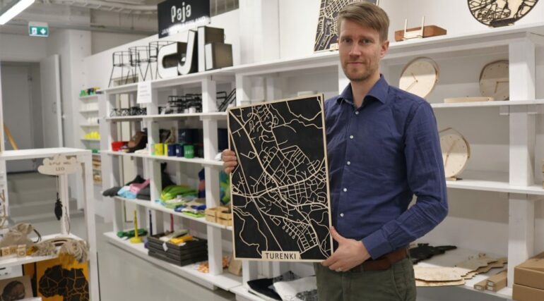 Yksi Papurinon yrittäjistä, Olli Tuomela, esittelee vanerista tehtyä karttaa Turengista-